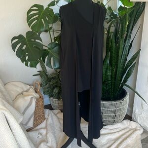 Black long sleeveless open front jacket with low side slits